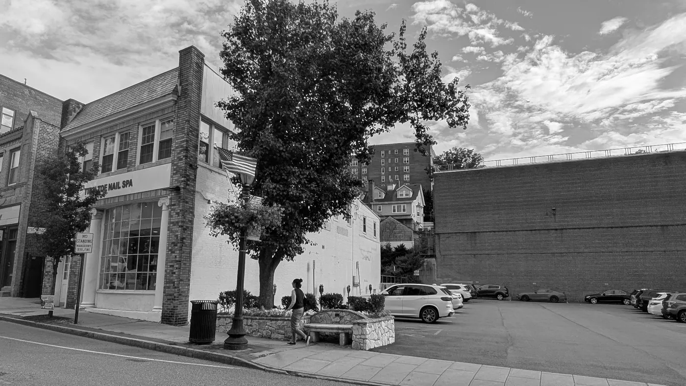 Main Street in Tuckahoe looking toward 62 Main Street, with a public metered parking lot beside the building.