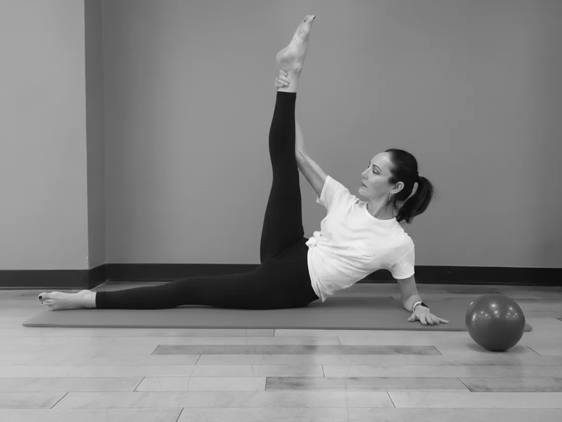 Jennifer Pagoto teaching a mat Pilates side-lying leg series with a mini stability ball.