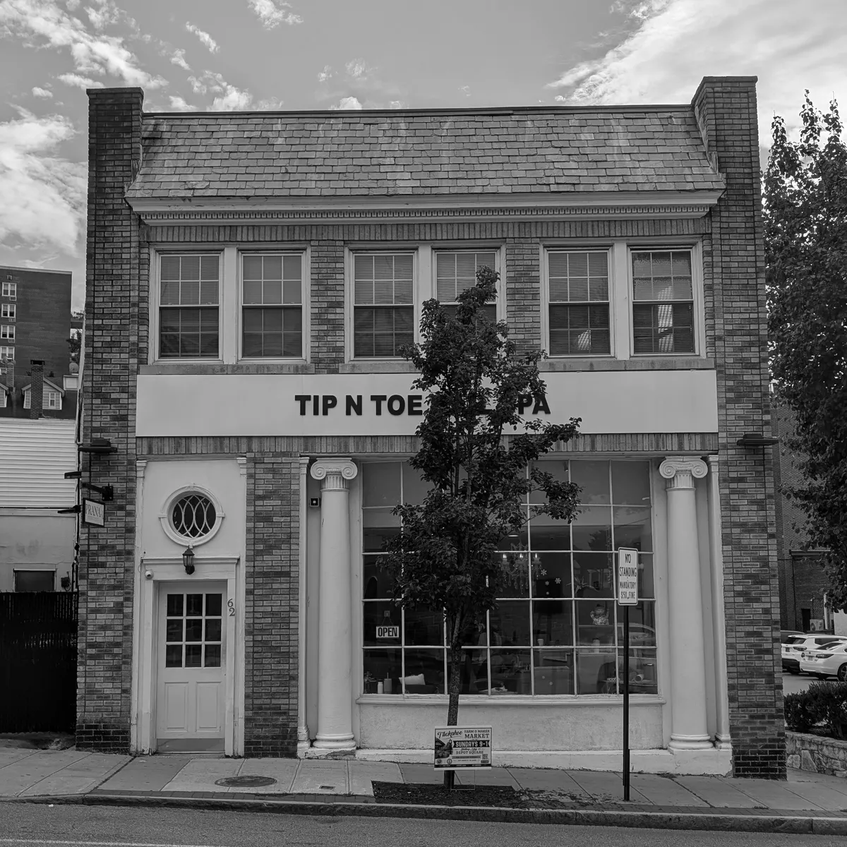 62 Main Street, Tuckahoe: a two-storey brick building with a nail salon storefront on the right and a plain white door on the left.